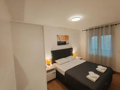 a bedroom with a bed with two white towels on it at Surčin Central Stay in Surčin
