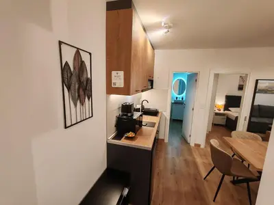 a kitchen and living room with a table and a dining room at Surčin Central Stay in Surčin