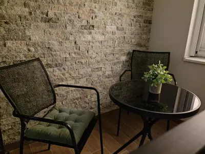 a table and two chairs and a table with a glass table and a tableablish at Surčin Central Stay in Surčin