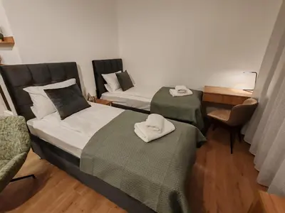 a room with two beds and a chair and a desk at Surčin Central Stay in Surčin