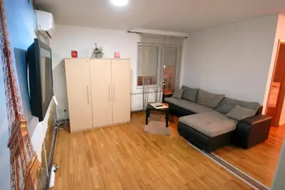 a living room with a couch and a tv at Franstal Apartments in Belgrade