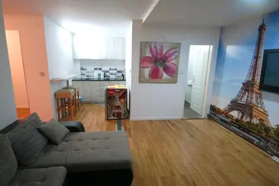 a living room with a couch and the eiffel tower at Franstal Apartments in Belgrade