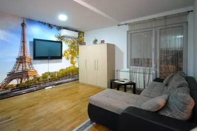 a living room with a couch and the eiffel tower at Franstal Apartments in Belgrade