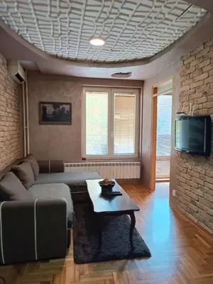 a living room with a couch and a tv at Front Apartment in Belgrade