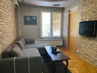 a living room with a couch and a tv at Front Apartment in Belgrade