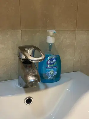 a bottle of detergent sitting on top of a sink at Front Apartment in Belgrade