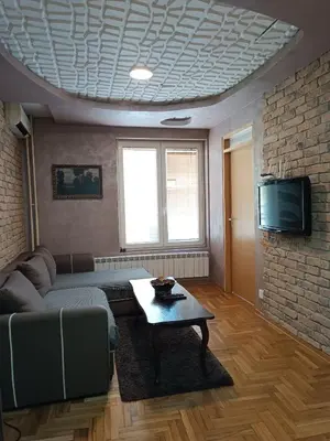 a living room with a couch and a table and a tv at Front Apartment in Belgrade