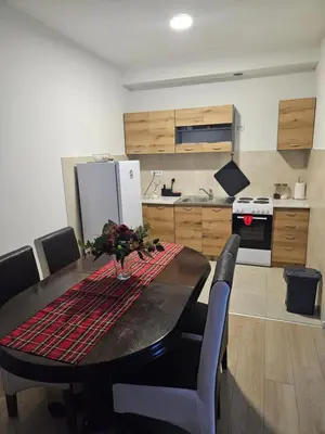 a kitchen with a table with chairs and a refrigerator at Miss Lux in Mladenovac