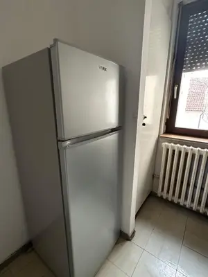 a white refrigerator in a room with a window at Apartment Crystal in Belgrade