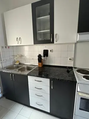 a kitchen with white cabinets and a sink at Apartment Crystal in Belgrade