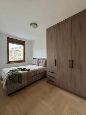 a bedroom with a bed and a large wooden cabinet at ATHOS Luxury Stay - Luxury and Comfort in the Center of Zvezdara in Belgrade