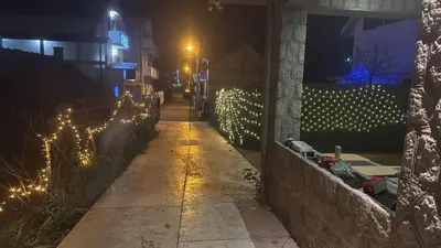 a sidewalk with lights on a wall at night at Apartman Andrej in Belgrade