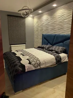 a bedroom with a blue bed with a blue headboard at Apartman Andrej in Belgrade