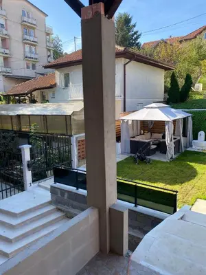 a house with a patio with an umbrella at Apartman Andrej in Belgrade