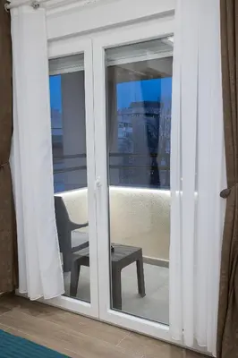 a sliding glass door to a balcony with a chair at M Corner in Belgrade