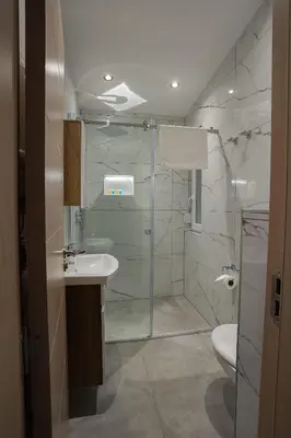 a bathroom with a shower and a sink and a toilet at M Corner in Belgrade