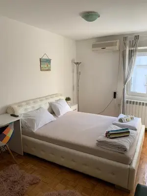 a bedroom with a white bed with a desk at Kosovska Street in Belgrade