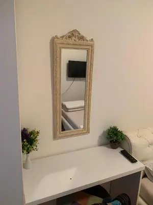 a mirror on a white wall with a white couch at Kosovska Street in Belgrade