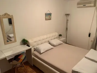a small bedroom with a white bed and a mirror at Kosovska Street in Belgrade