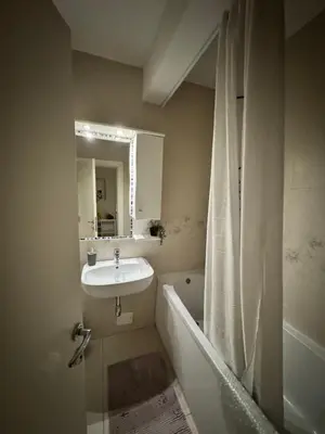 a bathroom with a sink and a bath tub with a mirror at Marse Stay in Belgrade