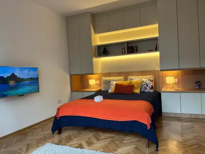 a bedroom with a bed with orange and blue sheets at Skadarlija Urban Nest in Belgrade
