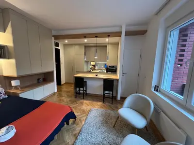 a room with a bed and a kitchen with a table at Skadarlija Urban Nest in Belgrade