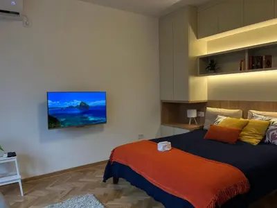 a bedroom with a bed and a tv on the wall at Skadarlija Urban Nest in Belgrade