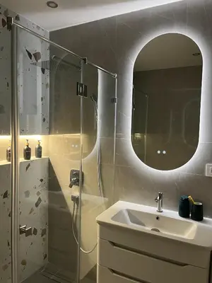 a bathroom with a sink and a shower with a mirror at Skadarlija Urban Nest in Belgrade