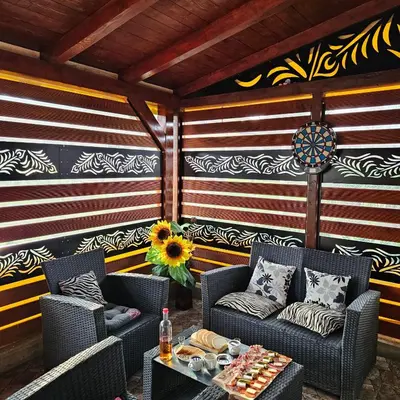 a patio with two chairs and a table and a wall with stripes at Diamond House Rent Vikendica in Beška