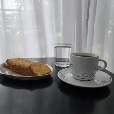 a table with a cup of coffee and a plate of bread at Diamond House Rent Vikendica in Beška