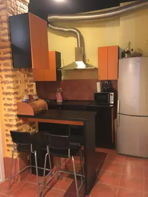a kitchen with a table and a refrigerator at Apartman Jovanovic in Belgrade