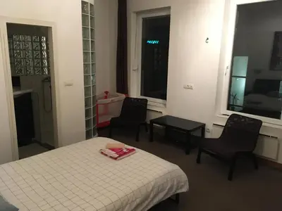 a room with a bed and two chairs and a table at Apartman Jovanovic in Belgrade