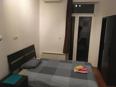 a bedroom with a bed in a room with a window at Apartman Jovanovic in Belgrade