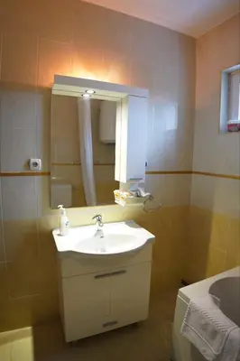 a bathroom with a sink and a mirror at Apartmani Kula in Novi Banovci