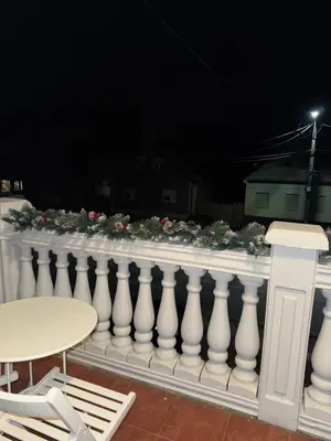 a white railing with flowers on it at night at Apartmani Kula in Novi Banovci