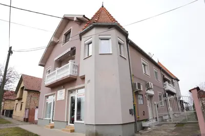 a pink and white building on a street at Apartmani Kula Novi Banovci Svetosavska 137 in Belgrade
