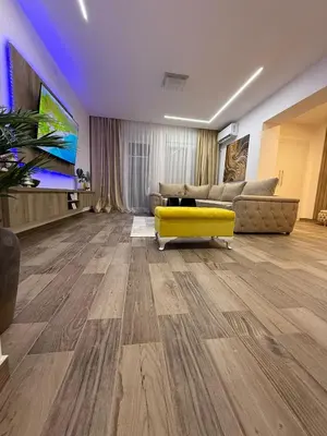 a living room with a yellow couch and a tv at Apartman 28 in Arandjelovac