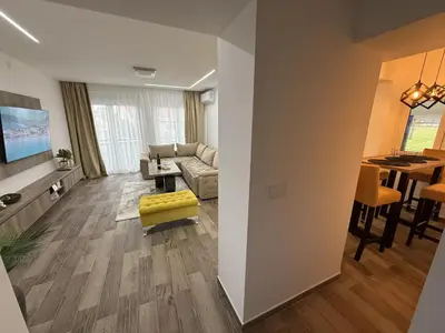 a living room with a couch and a dining room at Apartman 28 in Arandjelovac