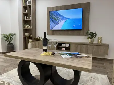 a living room with a table with wine glasses and a tv at Apartman 28 in Arandjelovac