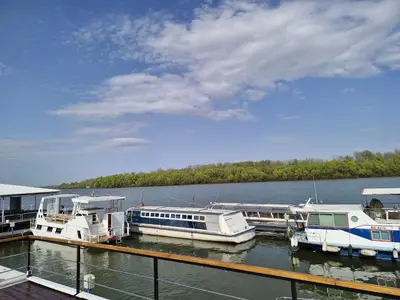 two boats docked at a dock on a lake at Bright Room Houseboat in Belgrade