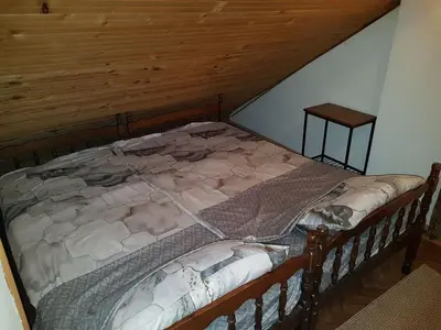 a bed in a room with a wooden ceiling at Ozon in Belgrade