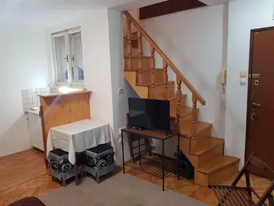 a living room with a staircase with a television at Ozon in Belgrade