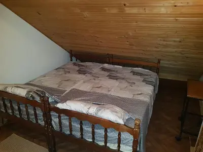 a bed in a room with a wooden ceiling at Ozon in Belgrade
