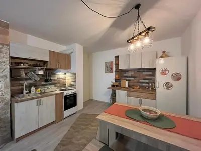 a kitchen with wooden cabinets and a white refrigerator at Apartman A 24 in Belgrade