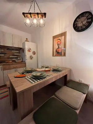 a kitchen with a table and a clock on the wall at Apartman A 24 in Belgrade