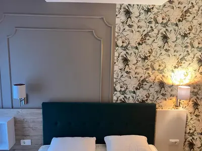 a bedroom with a bed with a floral wallpaper at Tomin sokak Apartment in Belgrade
