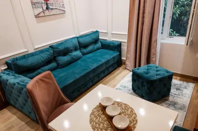 a living room with a blue couch and a table at Tomin sokak Apartment in Belgrade