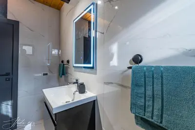 a white bathroom with a sink and a mirror at BlackPoolHouse in Belgrade
