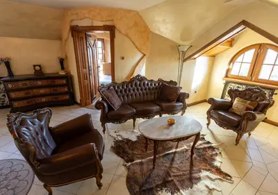 a living room with leather furniture and a table at Royal Casa in Belgrade