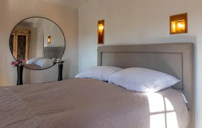 a bedroom with a white bed with a large mirror at Royal Casa in Belgrade